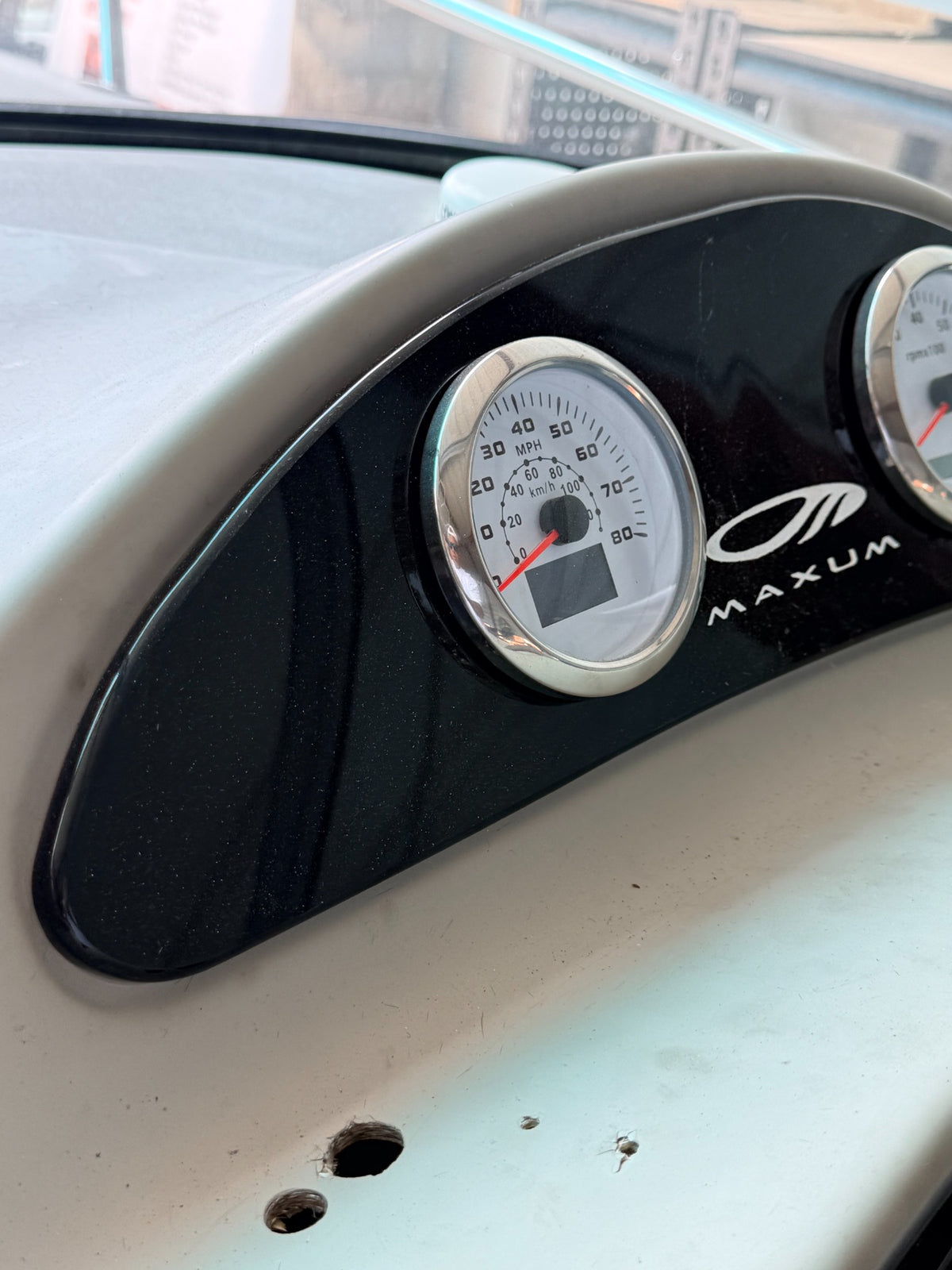 Custom black acrylic upper gauge backing panel with Maxum logo